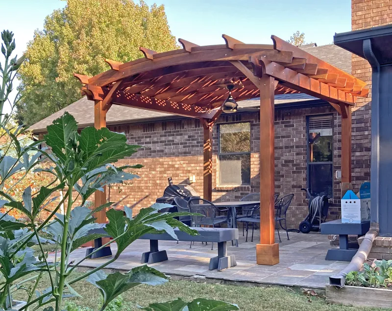 An arched redwood pergola over a garden path